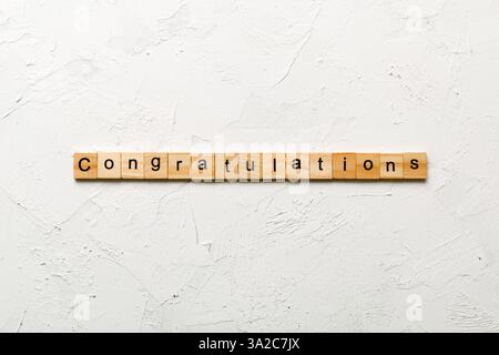 congratulazioni parola scritta su legno blocco. complimenti testo su cemento tavolo per la vostra desing, concetto. Foto Stock