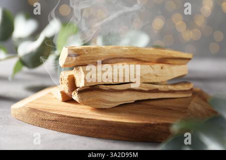 Palo Santo bastoncini che strisciano sul tavolo bianco, primo piano Foto Stock