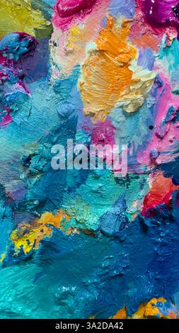 Sfondo di una tavolozza di vernice ad olio brillante primo piano, colore blu, giallo, rosa. Foto Stock