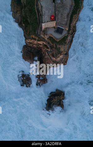 Veduta aerea del faro di Nazare - Farol de Nazare -, dove la gente si riunisce per guardare le grandi onde fare surf a Praia do Norte (North Beach), lista Foto Stock