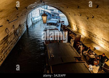 Barche Vodouch in legno ormeggiate al molo di partenza vicino al Ponte Carlo, pronte per un tour panoramico lungo il fiume Moldava, nel centro di Praga, Czechia Foto Stock