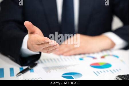 Uomo d'affari che analizza grafici finanziari e dati del mercato azionario Foto Stock