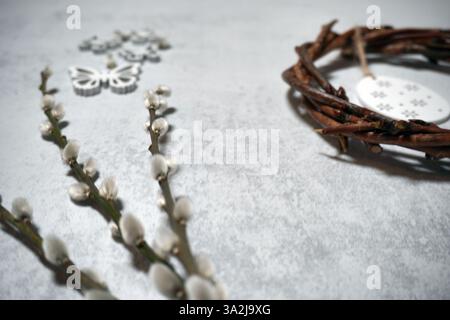 corona pasquale di rami di viti con filetto su sfondo grigio con copyspace. decorazione con uova Foto Stock