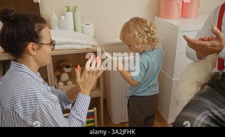 Madre, padre e figlio trascorrono del tempo insieme in casa, condividendo amore e felicità nel loro accogliente salotto di casa. Foto Stock