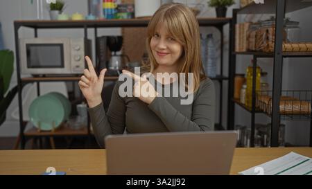 Donna che punta in un moderno ambiente d'ufficio, mette in mostra una posa sicura sul posto di lavoro, con arredi eleganti e un ambiente professionale. Foto Stock