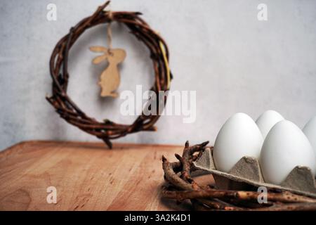 corona pasquale di rami di viti con filetto su sfondo grigio con copyspace. decorazione con uova Foto Stock