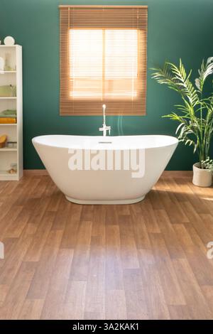 Un bagno moderno con elegante vasca indipendente abbinata a dettagli naturali Foto Stock