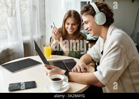 Una coppia amorevole siede vicino a un tavolo accogliente, interagendo l'uno con l'altro mentre si gusta un drink. Foto Stock