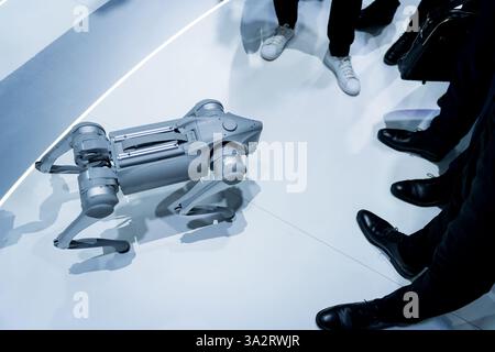 Un cane robot che cammina e gioca intorno alle persone in una fiera tecnologica. Concetto di innovazione ingegneristica robotica e intelligenza artificiale ai Foto Stock