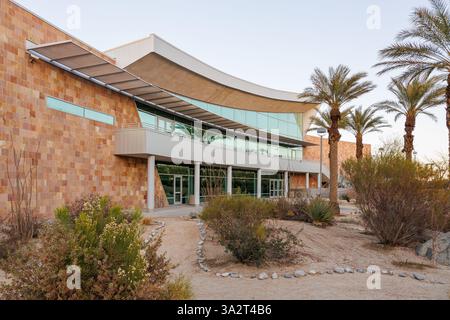 University of California, Riverside UCR Palm Desert Center al crepuscolo con palme e arbusti davanti Foto Stock