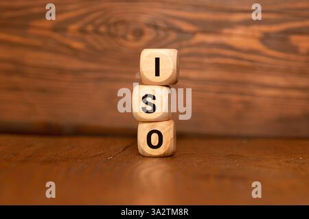 Concetto di certificazione di controllo qualità ISO. Cubi di legno con l'abbreviazione ISO con un segno di spunta. Foto Stock