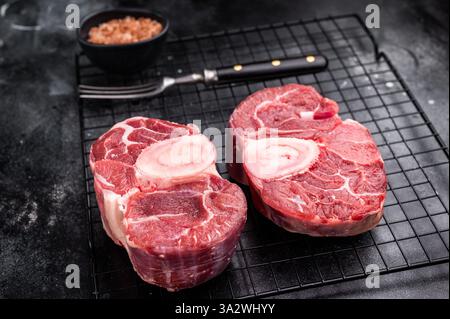 Ossobuco crudo fresco codolo di vitello Premium, ideale per cucinare lentamente e creare pasti sostanziosi e confortanti che impressionano. sfondo nero. vista dall'alto. Foto Stock