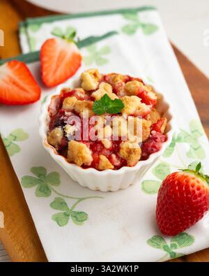 Fragole fatte in casa sbriciolano in una muffa singola, cotte nel forno. Foto Stock