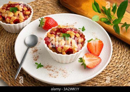Fragole fatte in casa sbriciolano in una muffa singola, cotte nel forno. Foto Stock