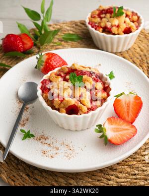 Fragole fatte in casa sbriciolano in una muffa singola, cotte nel forno. Foto Stock