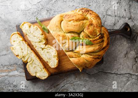Pesto di basilico fresco con pane intrecciato primo piano su un tavolo di legno. Vista dall'alto orizzontale Foto Stock