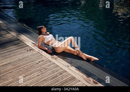Vicino alla piscina. Donna in bikini bianco. Foto Stock