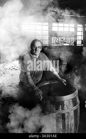 Un produttore di botti di whisky, o cooper, a Speyside Cooperage, vicino a Craigellachie, Moray, Scozia Foto Stock
