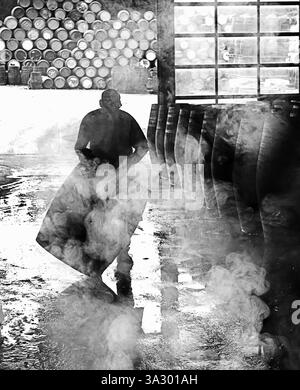 Un produttore di botti di whisky, o cooper, a Speyside Cooperage, vicino a Craigellachie, Moray, Scozia Foto Stock