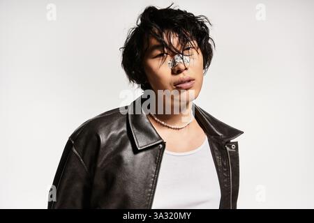Giovane asiatico con intonaco sul naso, vestito elegantemente, posa in uno studio. Foto Stock