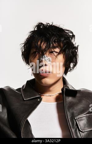 Uomo asiatico con intonaco sul naso che indossa giacca di pelle e collana di perle Foto Stock