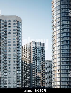 Quartiere moderno con alti edifici residenziali. Facciate di eleganti condomini al tramonto. Foto Stock