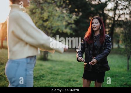 Due amici che abbracciano all'aperto in un parco durante un pomeriggio di sole Foto Stock