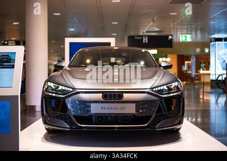07.03.2025 , Aeroporto Internazionale di Monaco, Germania. Berlina elettrica Audi e-tron GT esposta all'interno del terminal dell'aeroporto. Vista frontale, bassa profondità di fiel Foto Stock