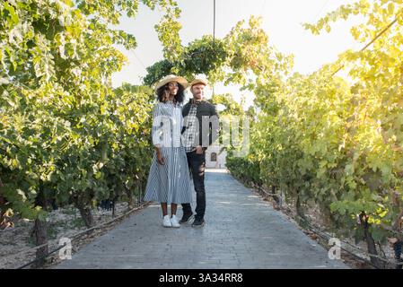 felice giovane coppia interrazziale in vacanza in un vigneto Foto Stock