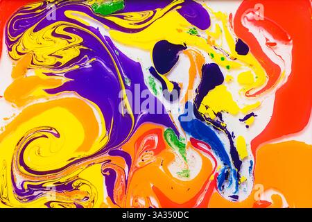 Un mix vivace di colori vorticosi tra cui arancione, giallo, viola e blu crea una visuale dinamica e astratta su una superficie liscia e lucida. Ideale Foto Stock