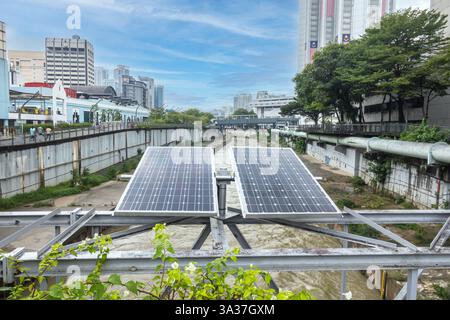 Pannelli solari installati su un corpo d'acqua, un canale o un fiume, con uno skyline della città sullo sfondo, Kuala Lumpur Malesia Foto Stock