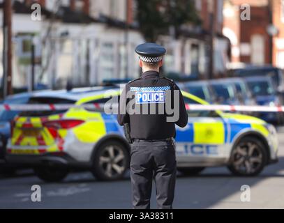 Agente di polizia fotografato da dietro su una scena del crimine nel Regno Unito. Foto Stock