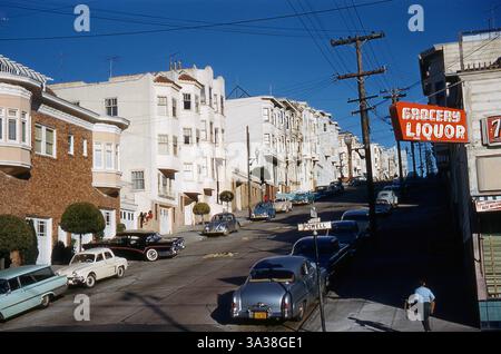 Il ragazzo che porta i pattini a rotelle si dirige su Powell Street, San Francisco. 1959. Le auto parcheggiate includono Volkswagen Beetle, Mercury 1951, Buick Roadmaster e Renault Dauphine Foto Stock