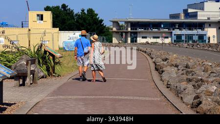 Coppia che cammina lungo Cardiff Bay Barrage Cardiff, Galles del Sud, Regno Unito, Regno Unito. Data: Luglio 2024. Estate Foto Stock