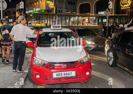 Tassista accanto al suo taxi, Jln Bukit Bintang, Bukit Bintang, notte, Kuala Lumpur, Malesia Foto Stock