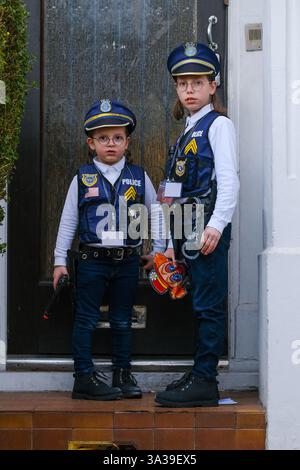 Londra, Regno Unito. 14 marzo 2025. I bambini si vestono da agenti di polizia mentre visitano una casa locale. La comunità ebraica ortodossa si è riunita a Stamford Hill per festeggiamenti gioiosi di Purim con musica e balli, poiché molti bambini e adulti sono stati visti indossare costumi fantasiosi nel quartiere. Credito: Fotografia dell'undicesima ora/Alamy Live News Foto Stock