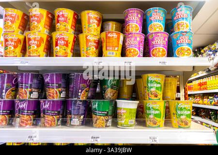 Scaffali riforniti con varie marche di spaghetti istantanei, prevalentemente Maggi, in un KK Mart di Kuala Lumpur. spaghetti istantanei a tazza o a tazza Foto Stock
