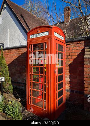 Stazione di defibrillazione su strada con defibrillatore in un vecchio chiosco telefonico rosso con vernice staccabile. Foto Stock