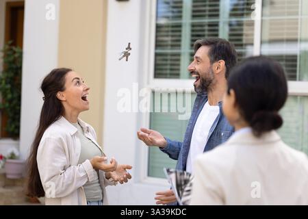 Allegra coppia eccitata di nuovi proprietari di case che festeggiano l'acquisto di una casa Foto Stock