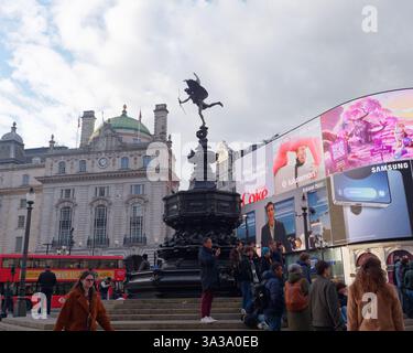 La Shaftesbury Memorial Fountain, alias Eros a Piccadilly Circus, con schermo iconico, edificio, London Bus e folle a Londra, marzo 2025 Foto Stock