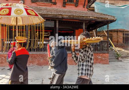 Dunbar Square, Bhaktapur, Nepal - 10 febbraio 2025 - parte di una processione di nozze che include una candela del cibo e un ombrello Foto Stock