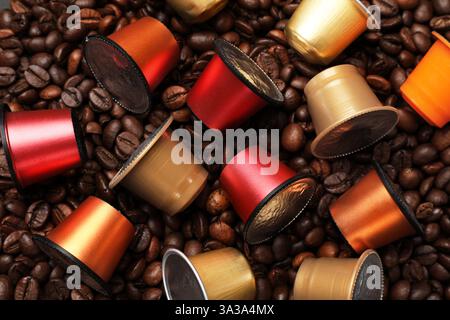 Molte capsule di caffè sui chicchi, vista dall'alto Foto Stock