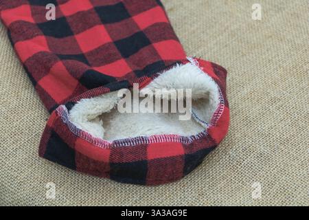 La manica a quadri di bufali rossa e nera con fodera bianca fuzzy all'interno della tasca Foto Stock