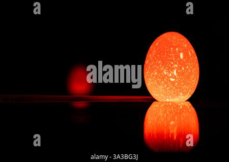 Nowruz. Festival di Primavera Cinese. Pasqua ebraica. Pagano. Uovo di pasqua colorato e luminoso. Sfondo nero con uovo di pasqua. 20 Foto Stock