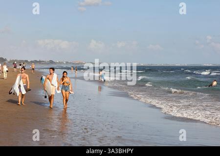 I giovani camminano lungo la spiaggia di Canggu a Canggu, Bali, Indonesia. Foto Stock