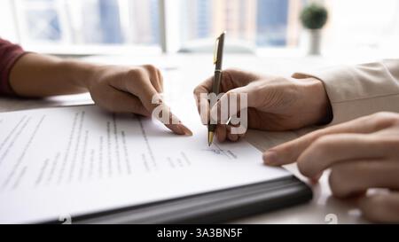 Primo piano dell'acquirente e del venditore che firma l'accordo Foto Stock