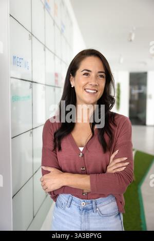 Felice donna leader di progetto aziendale in piedi alla scrum tasking board Foto Stock