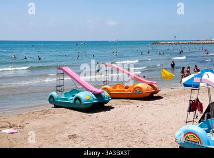 Pedalò sulla spiaggia, splendida giornata estiva a Playa del Estañol, Sitges, Costa del Garraf, Barcellona, Spagna Foto Stock