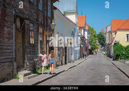 Città vecchia di Tallinn, vista in estate di due giovani turisti che esplorano una strada panoramica nella storica zona della città vecchia di Tallinn, Estonia. Foto Stock