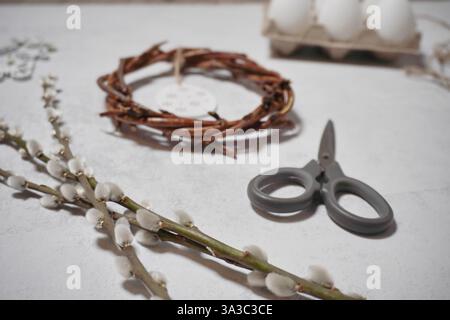 corona pasquale di rami di viti con filetto su sfondo grigio con copyspace. decorazione con uova Foto Stock